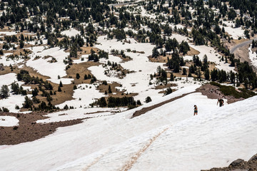 High altitude hiking trail to Lassen Peak still covered in snow on a sunny summer day; Lassen Volcanic National Park, Shasta County, California