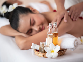 Fototapeta na wymiar White plumeria flower and Oil bottle Spa theme object. Background young asian woman on the bed mattresses In the Spa. Thai massage for health
