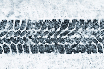 Black tyre mark shape on snowy frozen blue road background.