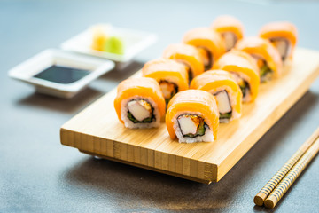 Salmon fish meat sushi roll maki on wood plate