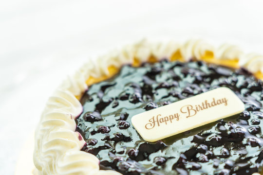 Blueberry cheese cake with happy birthday sign on top