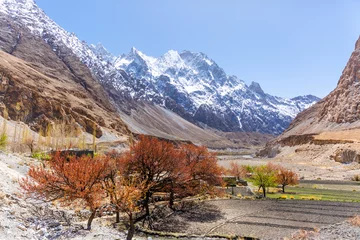 Fotobehang K2 Beautiful autumn scene along Karakorum highway with layers of snow mountains and blue sky background
