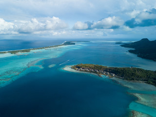 Fototapeta na wymiar Luxury overwater villas with coconut palm trees, blue lagoon, white sandy beach at Bora Bora island, Tahiti, French Polynesia