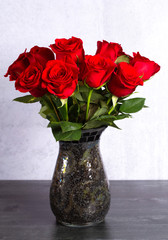Dozen Red Roses in a Vase on a Wooden Table