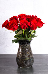 Dozen Red Roses in a Vase on a Wooden Table