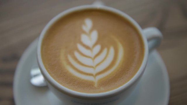Coffee Cappuccino cup top view close up with coffee latte art in cafe