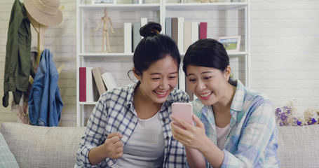 asian girls watching football match by mobile