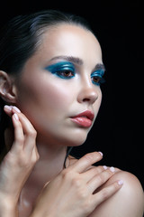 Young woman with perfect skin and blue-green smoky eyes eye shadows