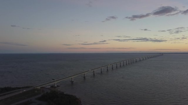 Aerial view of Confederation Bridge to Prince Edward Island during a vibrant sunny sunrise. Taken in Cape Jourimain National Wildlife Area, New Brunswick, Canada.