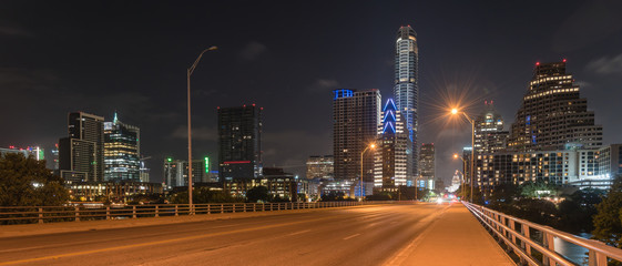 Panorama view downtown Austin at night with traffic light trail lead to Texas State capitol...