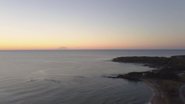 Aerial view of a Beautiful Sandy Beach on the Atlantic Ocean Coast during a vibrant sunrise. Taken near in Pabos Mills, Quebec, Canada.