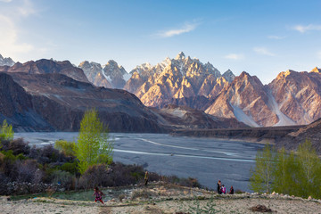 Tupopdan-berg ook bekend als Passu-kegels of Passu-kathedraal, grote rotsen overal en blauw kristal van de Hunza-rivier bij zonsondergang, ten noorden van Pakistan