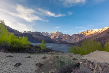 Fototapete Gasherbrum Tupopdan mountain also known as Passu Cones or Passu Cathedral, big rocks all over the place and blue crystal of Hunza river at sunset time ,Northern of Pakistan