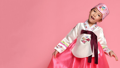 Korean little baby girl in traditional silk dress celebrate new year 2019 on pink background