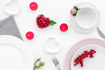 Elegant table setting with white and pink plates and wineberry decor on white background top view