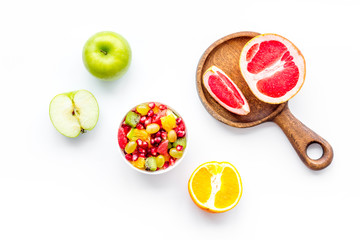 Healthy diet concept. Fruit salad near fresh fruits on white background top view