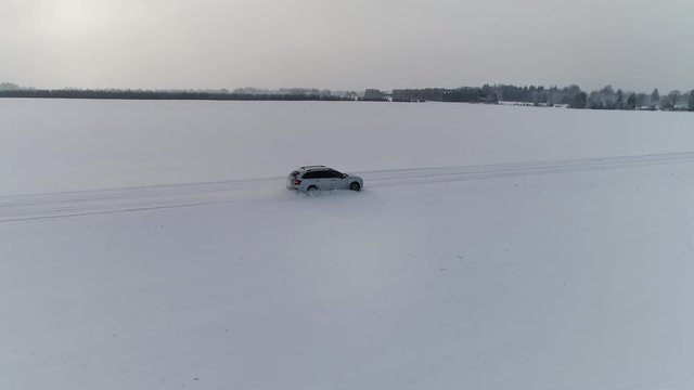 Car on a snowy winterroad. Shot by drone