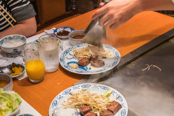 Chef serve stir fried bean sprout with beef steaks to customers
