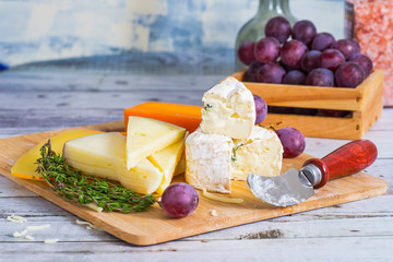 cheese with grapes on a wooden table
