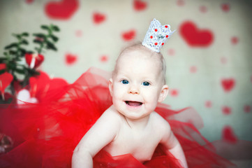Valentine's Day concept copy space. Little baby with kisses from lipstick. A girl with a red heart Saint Valentine. Red box with a gift, hearts, place and background.