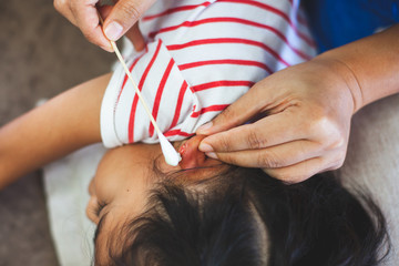 Parent helping her child perform first aid ear injury after she has been an accident