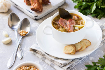 Thick pea soup with smoked meats in a white plate