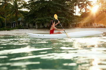 Summer Travel. Woman Kayaking In Sea Water Near Green Island