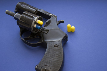  pill-loaded revolver on the blue background