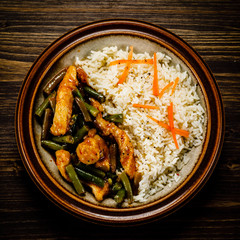 Grilled meat, white rice and vegetables on wooden table
