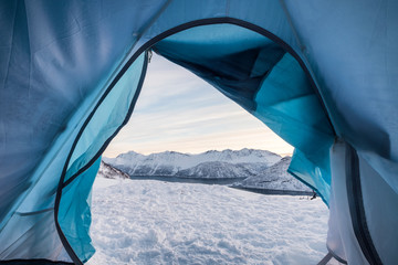 Relaxing inside tent camping opening with snowy mountain