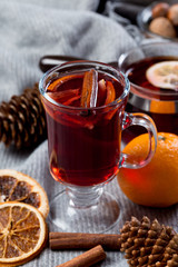 Mulled wine in glasses with orange and spices with gray scarf.