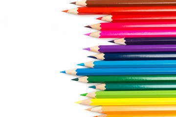 Colour pencils on white background, top view.