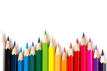 Colour pencils on white background, top view.