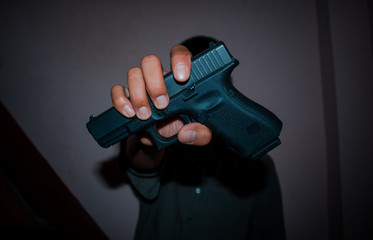 A man holding  gun in hand, the ship ready to shoot.A man is killer.