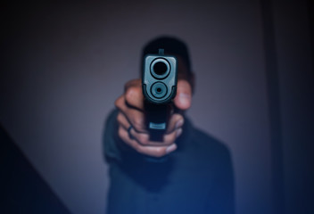 A man holding  gun in hand, the ship ready to shoot.A man is killer.