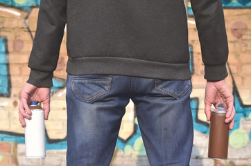 Graffiti artist with a spray can in his hand. Back view