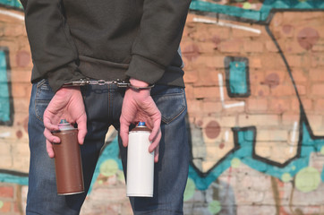 Young hoodlum caught by the police and shackled in handcuffs wit