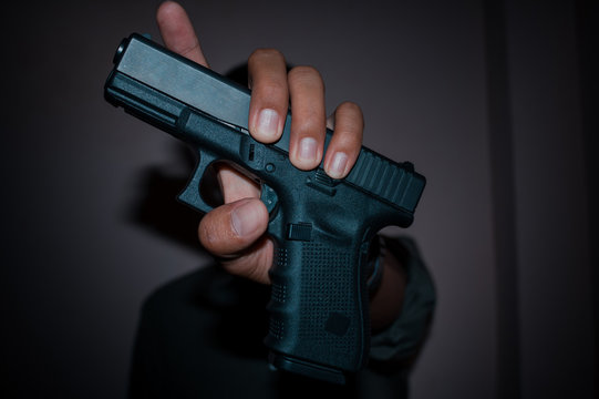 A man holding  gun in hand, the ship ready to shoot.A man is killer.