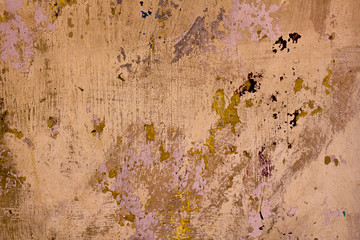 Old beige dirty wall with scratches and green pink paint stains. rough surface texture