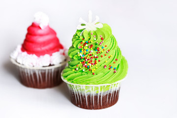 Tasty holiday cupcakes on a white background