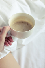 Sexy women relaxing in bad with cup of hot coffee