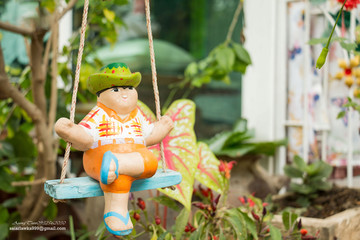 The doll is on the swing.