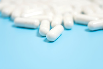 Fototapeta na wymiar white pills on blue background