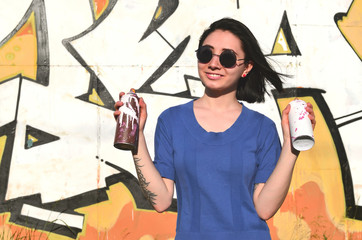Portrait of an emotional young girl with black hair and piercings. Photo of a girl with aerosol...