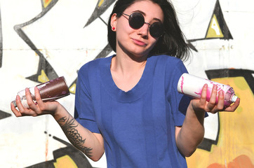 Portrait of an emotional young girl with black hair and piercings. Photo of a girl with aerosol...