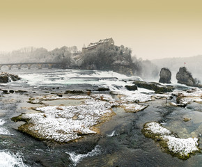 Rhine Falls in Switzerland on a winter evening with snow falling