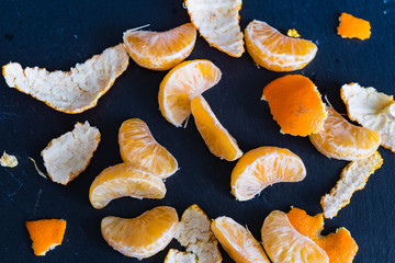 Mandarinen und Schnitze auf dunklem Hintergrund
