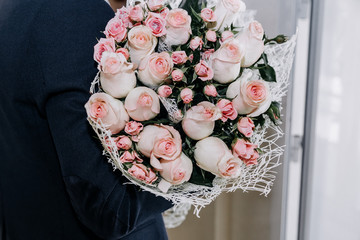 Beautiful bouquet with pink roses in men's hands