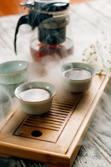 tea kettle with cups on a Chaban tea Board on a grey background