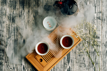 tea kettle with cups on a Chaban tea Board on a grey background